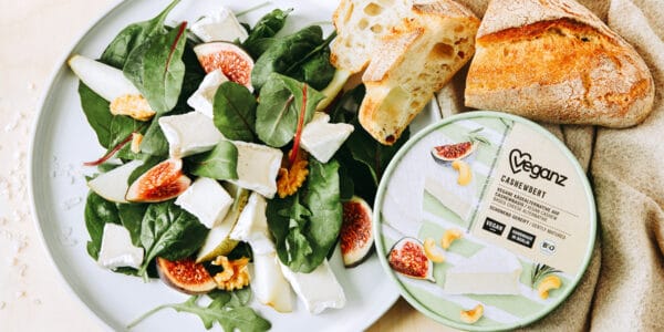 A salad with vegan cheese and baguette.
